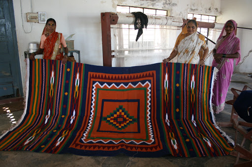 Artisans holding a Navalgund durrie