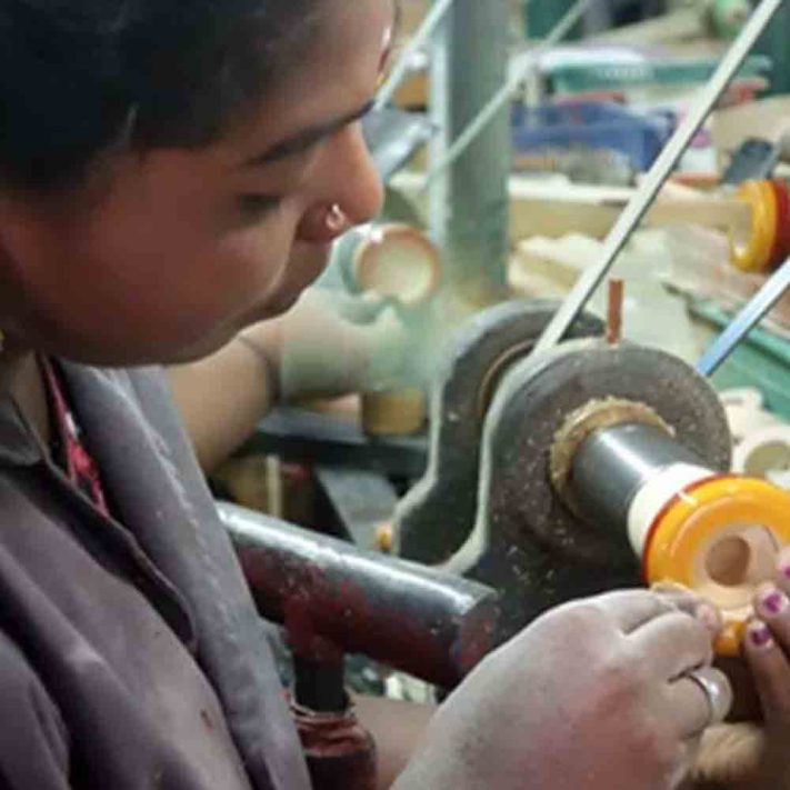 An artisan handcrafting a Channapatna toy