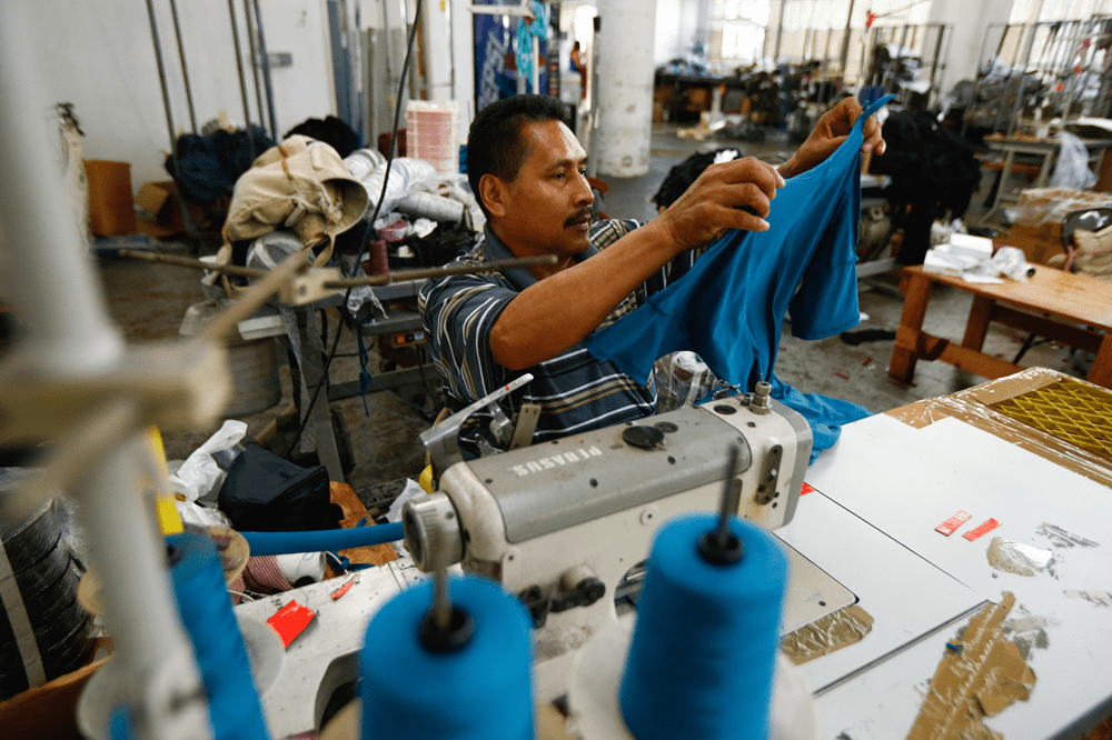 A factory tailor working on a piece of clothing