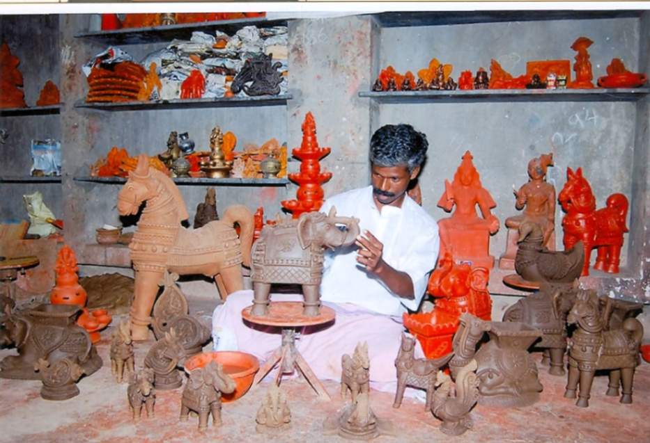 An artisan handcrafting offerings using villianur terracotta method