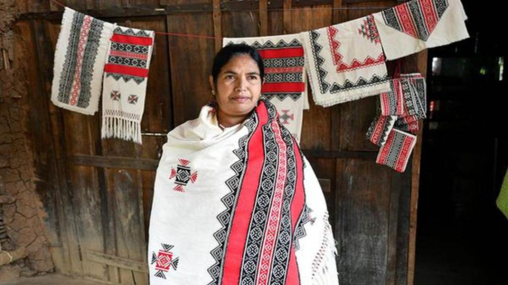 A woman showcasing a draped toda embroidery shawl