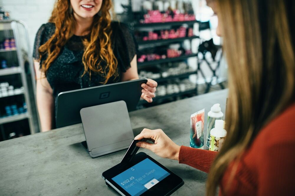 A customer making payment at checkout through POS system